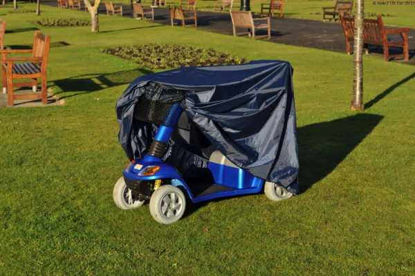 Electric mobility scooter covered with a rainproof cover for safe outdoor use.