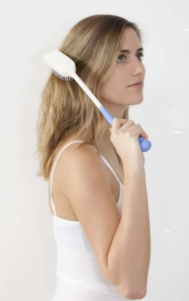 Soft woman brushing her hair with a hairbrush, natural hair care, grooming, beauty routine, female with long wavy hair.