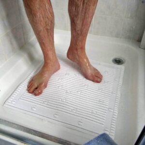 Wet feet on shower mat in accessible shower for mobility aids.