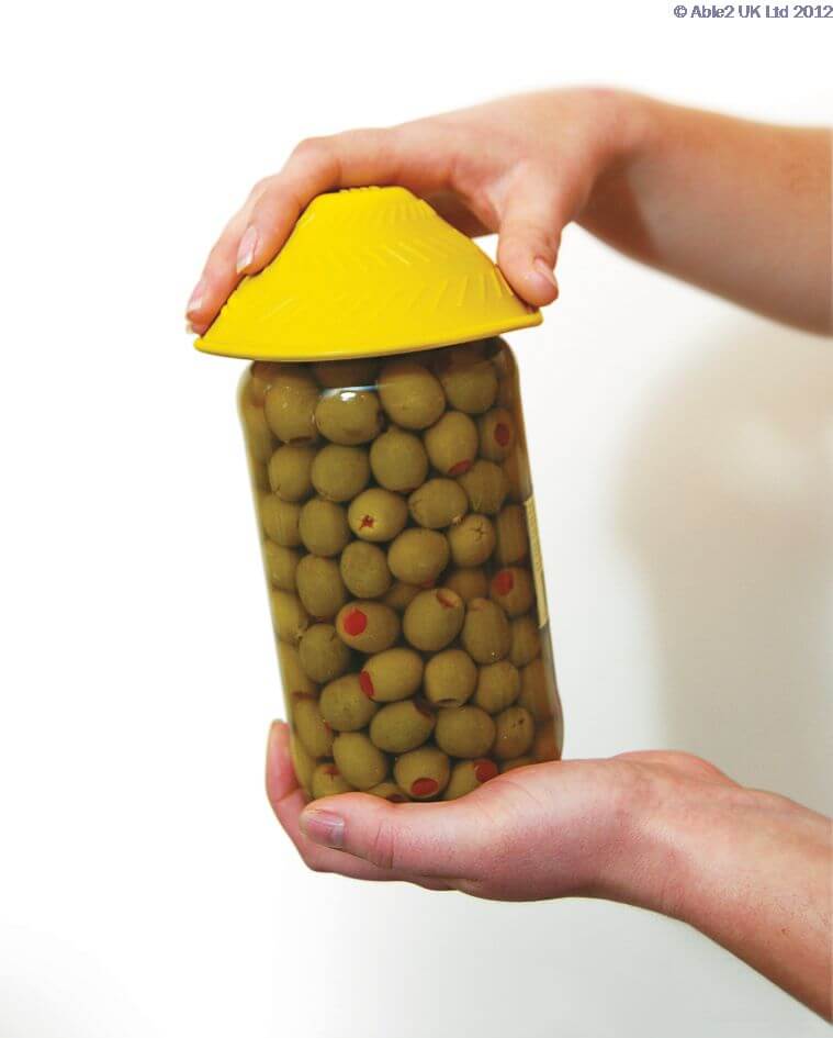 Fresh green olives in brine with red pimentos in a jar, stored for preservation and use.