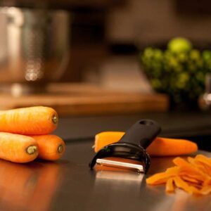 Good Grips Y Peeler Fresh carrots and vegetable peeler on kitchen countertop, healthy cooking preparation.