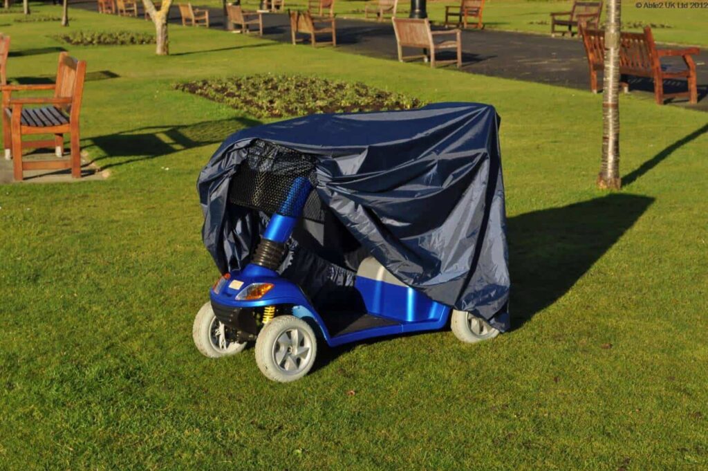 Electric mobility scooter covered with a rainproof cover for safe outdoor use.