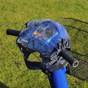 Splash Scooter Control Panel Cover Electric mobility scooter handlebar with basket on grassy ground.