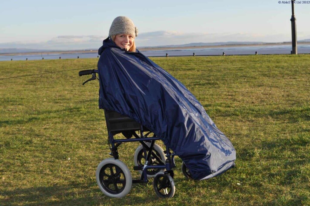 Lightweight mobility wheelchair with rain cover for outdoor use in the UK.