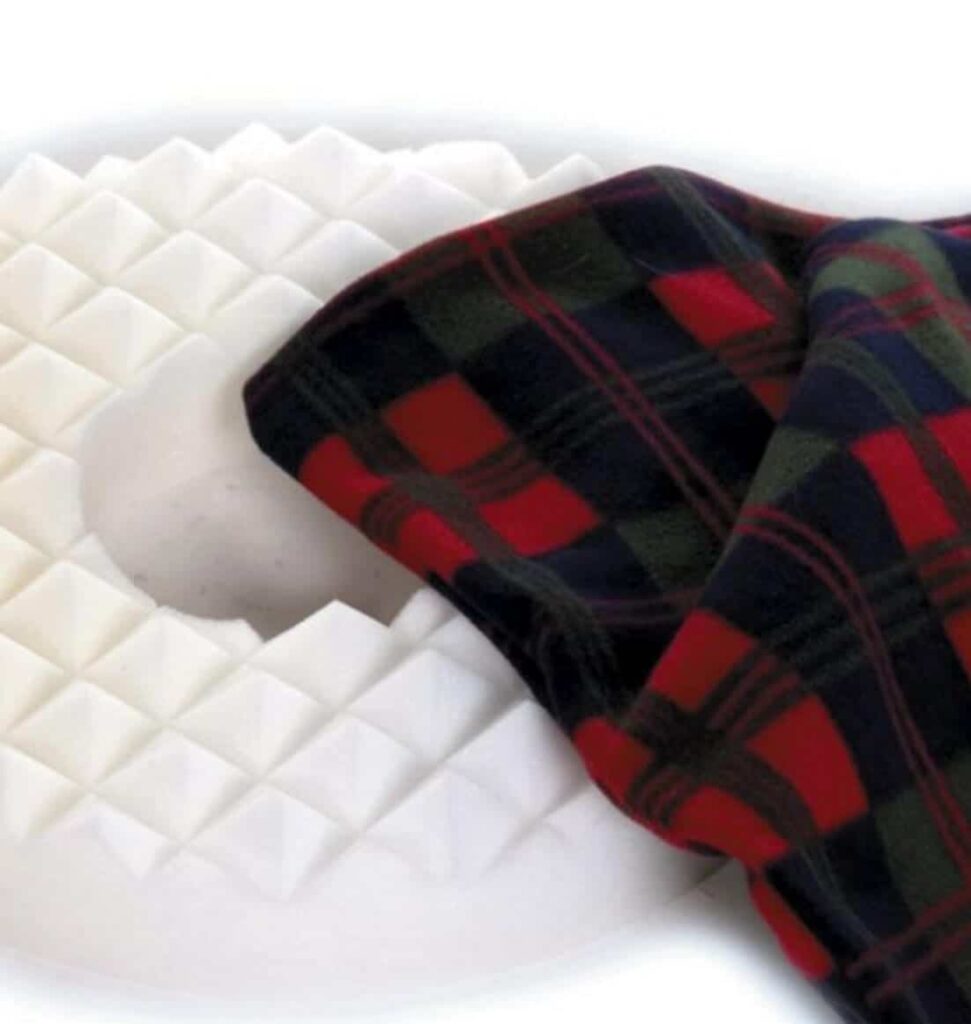 Comfortable foam mattress with memory foam and a cozy tartan blanket for mobility needs.