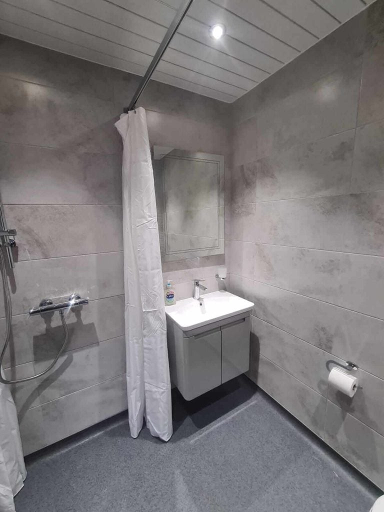 Accessible bathroom with walk-in shower and mobility aids, ideal for disabled and elderly users.