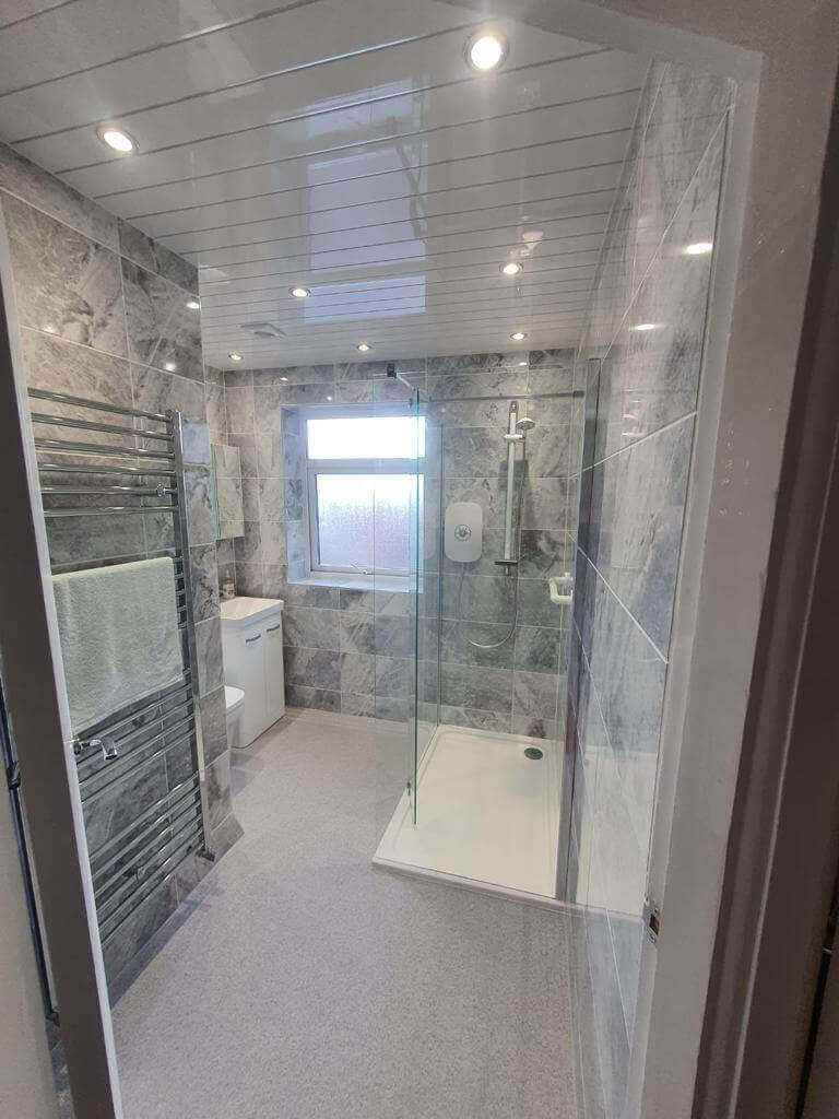 Accessible walk-in shower with grab bars and non-slip flooring for elderly mobility.
